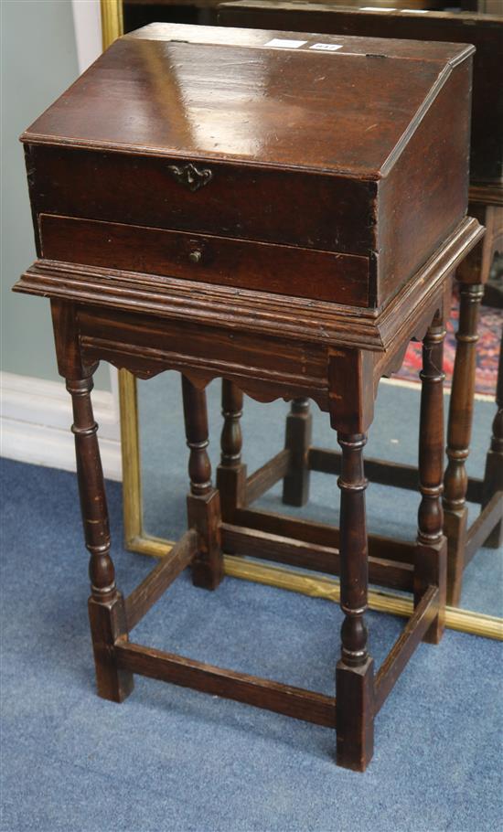 An 18th century mahogany slant front box, raised on an oak stand W.43cm